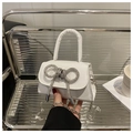 Detailed macro of white mini leather bag with rhinestone bow and silver chain strap - White