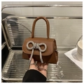 Détail du sac en cuir marron avec nœud en strass brillant et bandoulière en chaîne - Marron