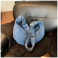 Detailed macro view of denim crescent bag with symmetrical pockets and silver metal buckle - Light Blue