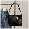 Close-up of black glossy bucket bag featuring a silver metal bow and knotted strap details - Black (Without Charm)