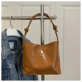 Detail view of caramel brown glossy leather hobo bag with a silver metallic bow decoration - Brown (Without Pendant)