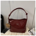 Detail of burgundy glossy tote bag featuring a silver bow buckle and plush bear charm - Red (With Charm)