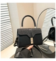 Dettaglio ravvicinato di una borsa in pelle nera con paillettes e serratura in metallo oro - Nero