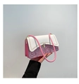 Detail van roze glittertextuur en witte leren flap met gouden sluiting op de tas - Roze