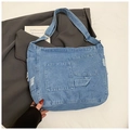 Dettaglio della borsa tote in denim azzurro con tasche applicate e bordi sfrangiati - Azzurro