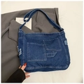 Dettaglio della borsa tote in denim con tasche vintage e finiture con bordi sfrangiati - Blu scuro