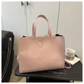 Detailansicht der rosa Ledertasche mit geprägtem Schriftzug auf einer strukturierten Fläche - Rosa