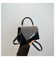 Primer plano de bolso de cuero bicolor con tela de sarga gris y cierre de metal dorado - Negro