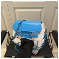 Detalle del bolso de mano en azul y blanco con herrajes dorados y diseño elegante - Azul