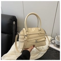 Close-up of beige Boston bag featuring decorative multi-belt straps and metallic buckles - Off White