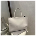 Detailaufnahme der weißen Leder-Einkaufstasche mit Prägung auf minimalistischem Display - Weiß