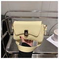 Detail of light yellow leather bag featuring a gold rectangular twist lock closure - Yellow