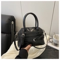Detail of glossy black shell bag with silver buckles and decorative belt straps - Black