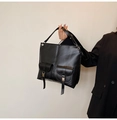 Dettaglio della borsa tote nera con due tasche frontali e dettagli in fibbia metallica - Nero