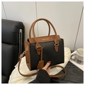 Detalle de bolso bandolera bicolor con textura de cuero negro y asas marrones - Negro
