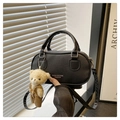 Detail van zwarte Boston tas met lychee textuur, riem en schattige beer hanger - Zwart Met Hanger