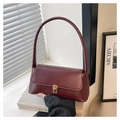 Dettaglio borsa baguette in pelle bordeaux con chiusura dorata vintage e tracolla piatta - Borgogna