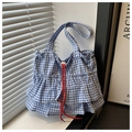 Detalle de bolso tote de cuadros azules con volantes de doble capa y cordón rojo vivo - Azul