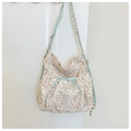 Macro detail of floral canvas bag with light blue plaid strap and bow decoration - Off White