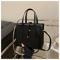 Detalle del bolso de mano minimalista en cuero PU negro con herrajes dorados y cordón - Negro