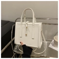 Vista detallada de un bolso cuadrado de cuero blanco brillante con hebilla metálica - Blanco