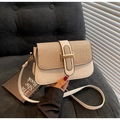 Borsa a tracolla bianca e dorata con fibbia a H e catena su divano di velluto - Bianco Sporco