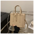 Detalle de un bolso de mano minimalista en cuero PU crema con herrajes dorados - Caqui