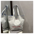 Dettaglio della borsa tote in tela bianca con fodera a righe blu e ricamo di lettere - Bianco Verticale