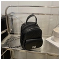 Chic black mini backpack with diamond quilting and silver chain straps on a modern stand - Black