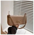 Detail of khaki leather handbag featuring a gold bow accent and tied knot strap detail - Khaki