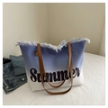 Detail der Canvas-Strandtasche mit Summer-Aufdruck, blauen Fransen und Ledergriffen - Dunkelblau