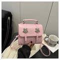 Detalle del mini bolso bandolera de cuero rosa con tachuelas de estrellas y letras - Rosa