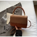 Detail of caramel brown woven patchwork handbag with wavy edges and leather texture - Brown
