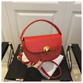 Detail of red crescent leather bag with sequin paneling and golden ball clasp - Red