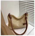 Close-up of woven straw handbag texture with brown leather strap and knot detail - Brown