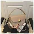 Nahaufnahme einer halbrunden Satteltasche mit goldenen Pailletten und Metallverschluss - Khaki