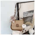 Détail d'un sac bandoulière beige avec foulard en soie rayé et porte-clé peluche blanc - Avec Charme de Poupée en Peluche / Kaki