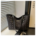 Detailansicht der schwarzen Stepptasche mit weißen Schleifenstickereien und Metalllogo - Schwarz