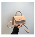 Détail d'un sac bandoulière beige avec poignée torsadée et boucle métallique - Kaki