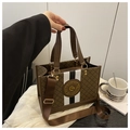 Detail of vintage brown monogram tote with striped webbing strap and metal emblem - Coffee