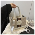 Detail of vintage canvas tote with leather handle and branded emblem on desk - White