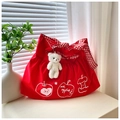 Detail of red travel tote with apple prints and a cute plush bear charm accessory - With Bear Pendant / Red