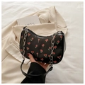 Close-up of black baguette bag with cherry print and silver chain strap handle - Black