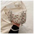 Detail of cherry print bag with silver chain strap on a minimalist aesthetic background - White
