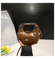 Détail du sac croissant marron caramel avec rivets argentés et boucle sur fond blanc - Marron