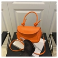 Fashionable bright orange crossbody bag with a unique twisted handle and smooth finish - Orange