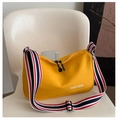 Detail of yellow canvas dumpling bag with striped wide shoulder strap on a chair - Yellow