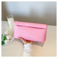 Close-up of pink woven texture on a large capacity envelope clutch held by hand - Pink