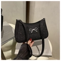 Detail of black glitter shoulder bag featuring a decorative silver metal bow clasp - Black