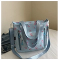 Détail du sac cabas bleu clair avec motifs de roses roses et poches avant pratiques - Bleu